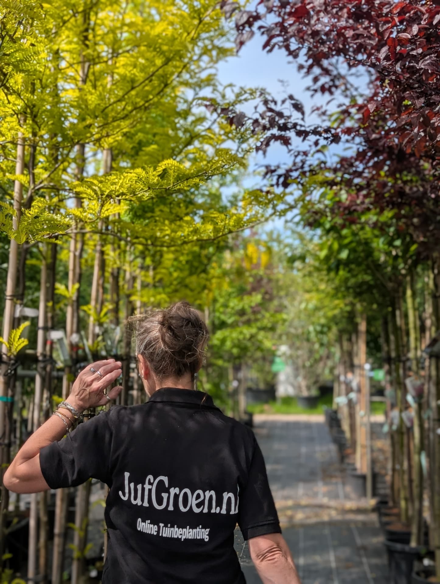 Nathalie tussen de bomen op de kwekerij